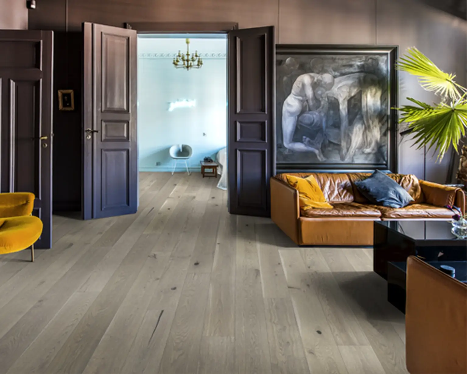 Stylish living space with light wood flooring, leather furniture, and dark walls.