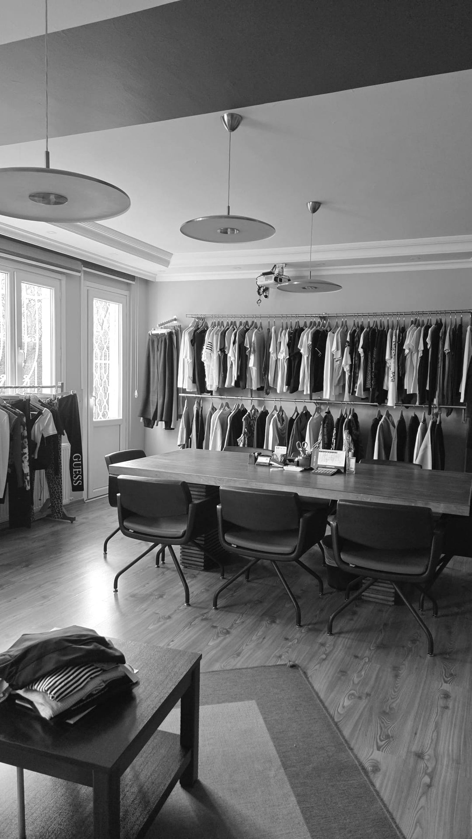 RSR Tekstil inside office/showroom, tables and shares with rails of clothes