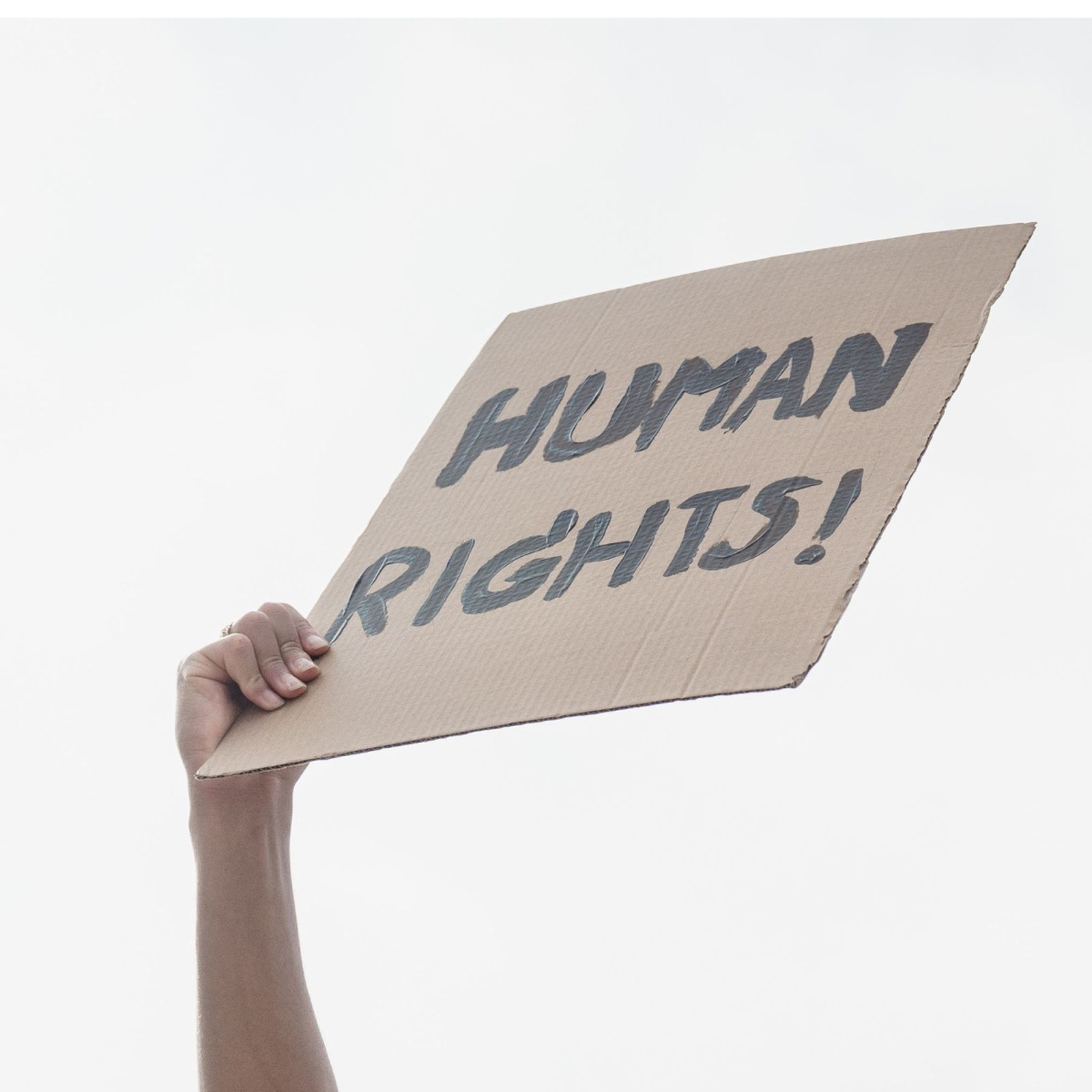 hand holding a cardboard tagged with "human rights"