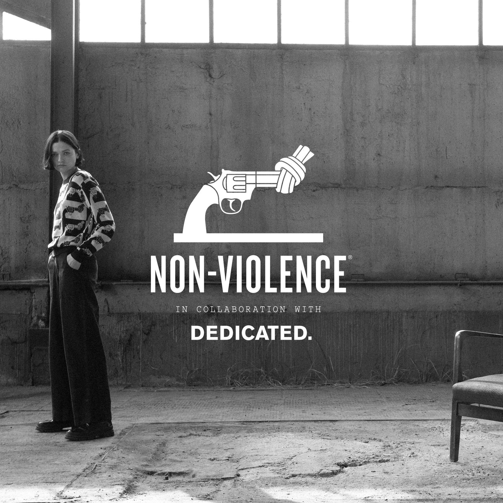 Person in patterned shirt stands in an industrial space with a knotted gun logo and "Non-Violence" text overlay.
