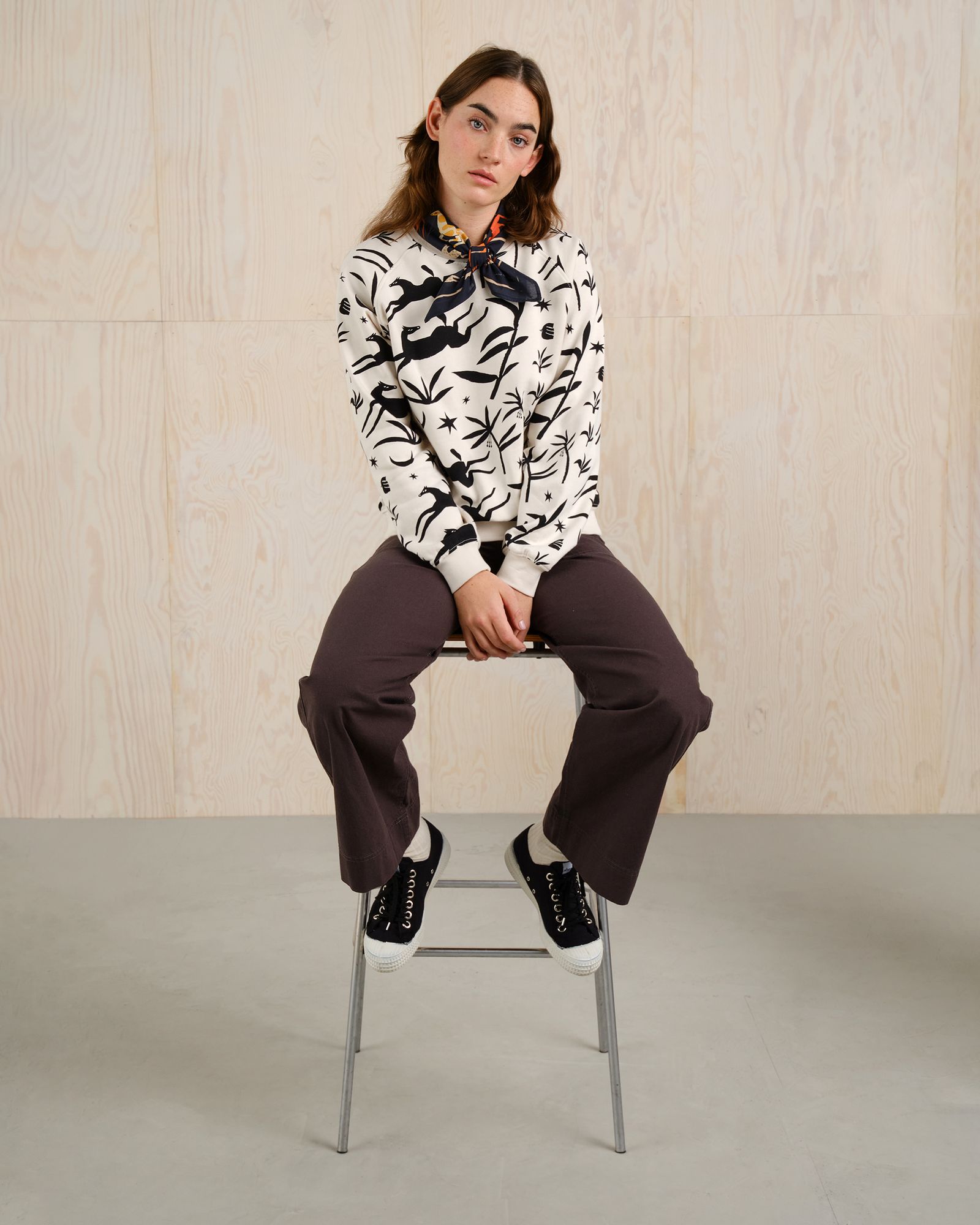 women sitting on a chair with a white sweater