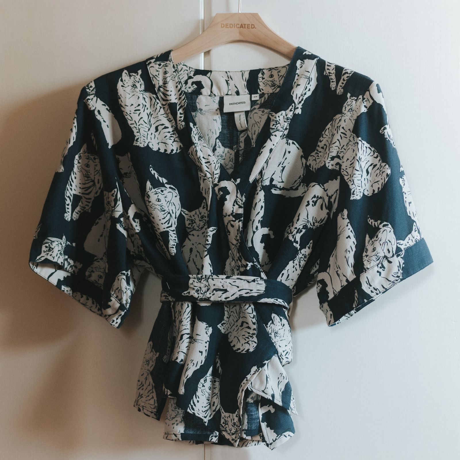 Top in blue with white cats on it hanging infront of a wardrobe