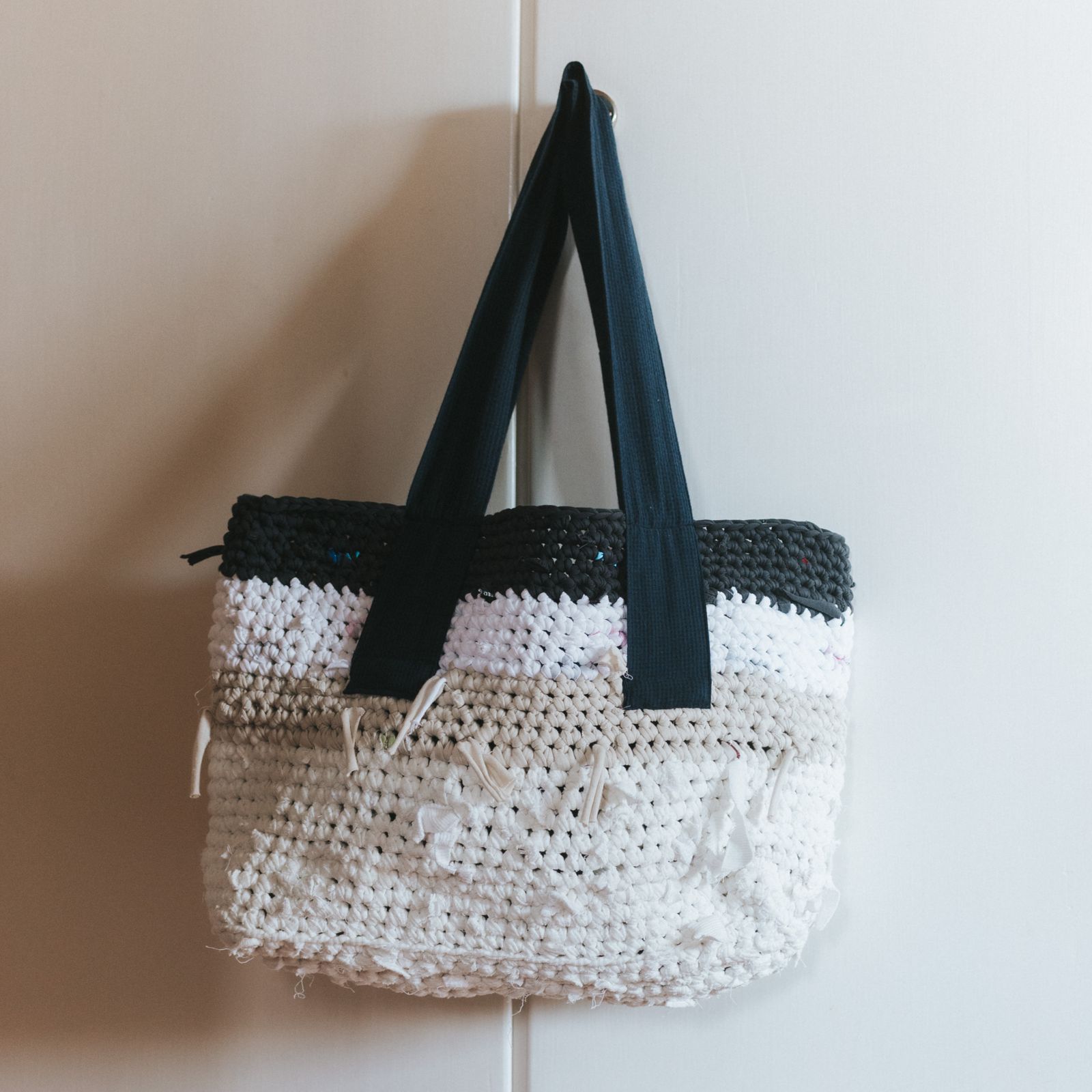 A bag hanging infront of a wardrobe