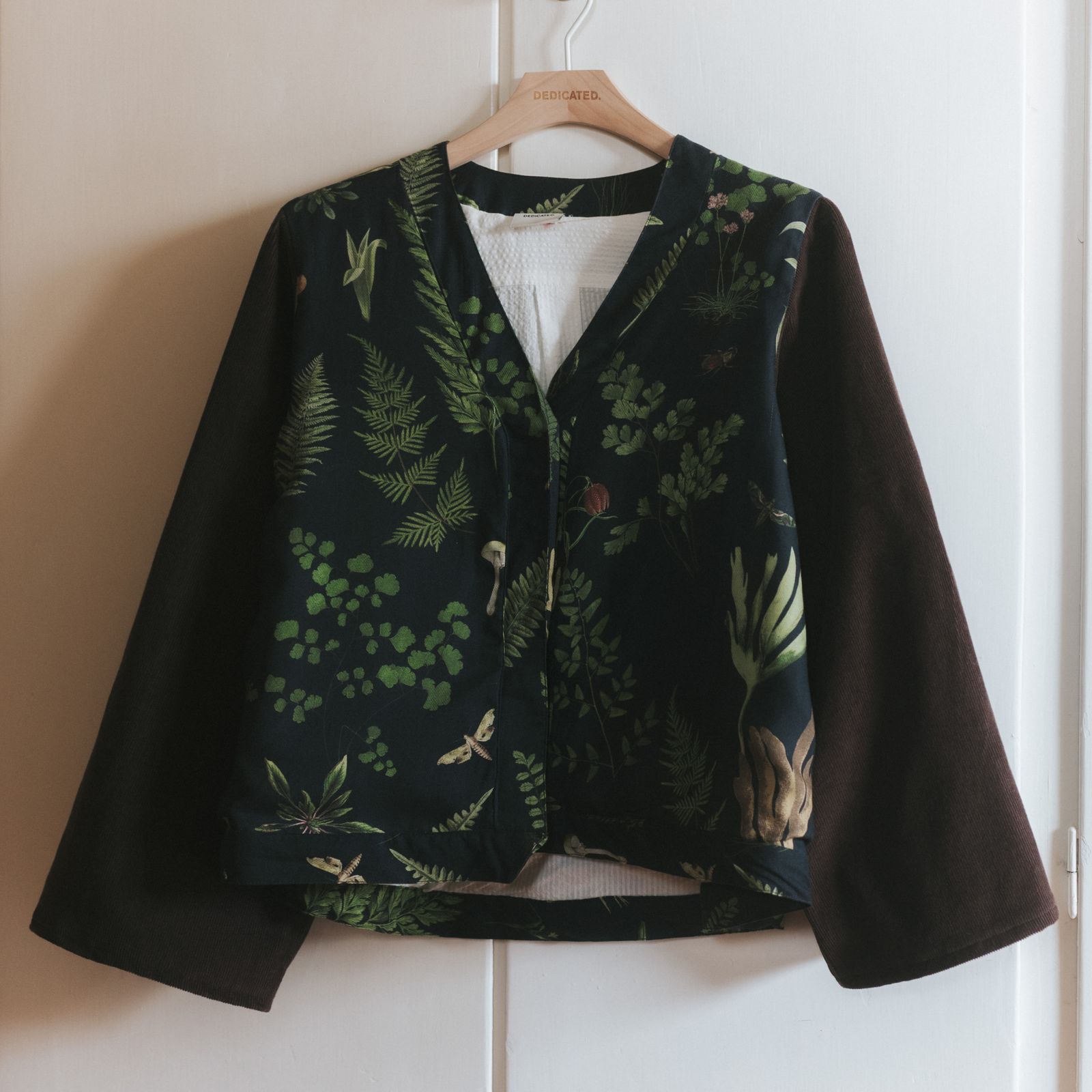 A jacket in Corduroy arms and Tencel front hanging infront of a wardrobe