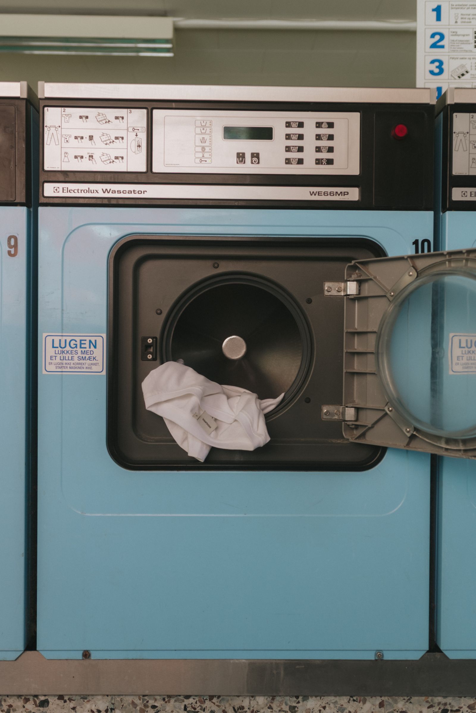 open blue laundry machine with clothes inside