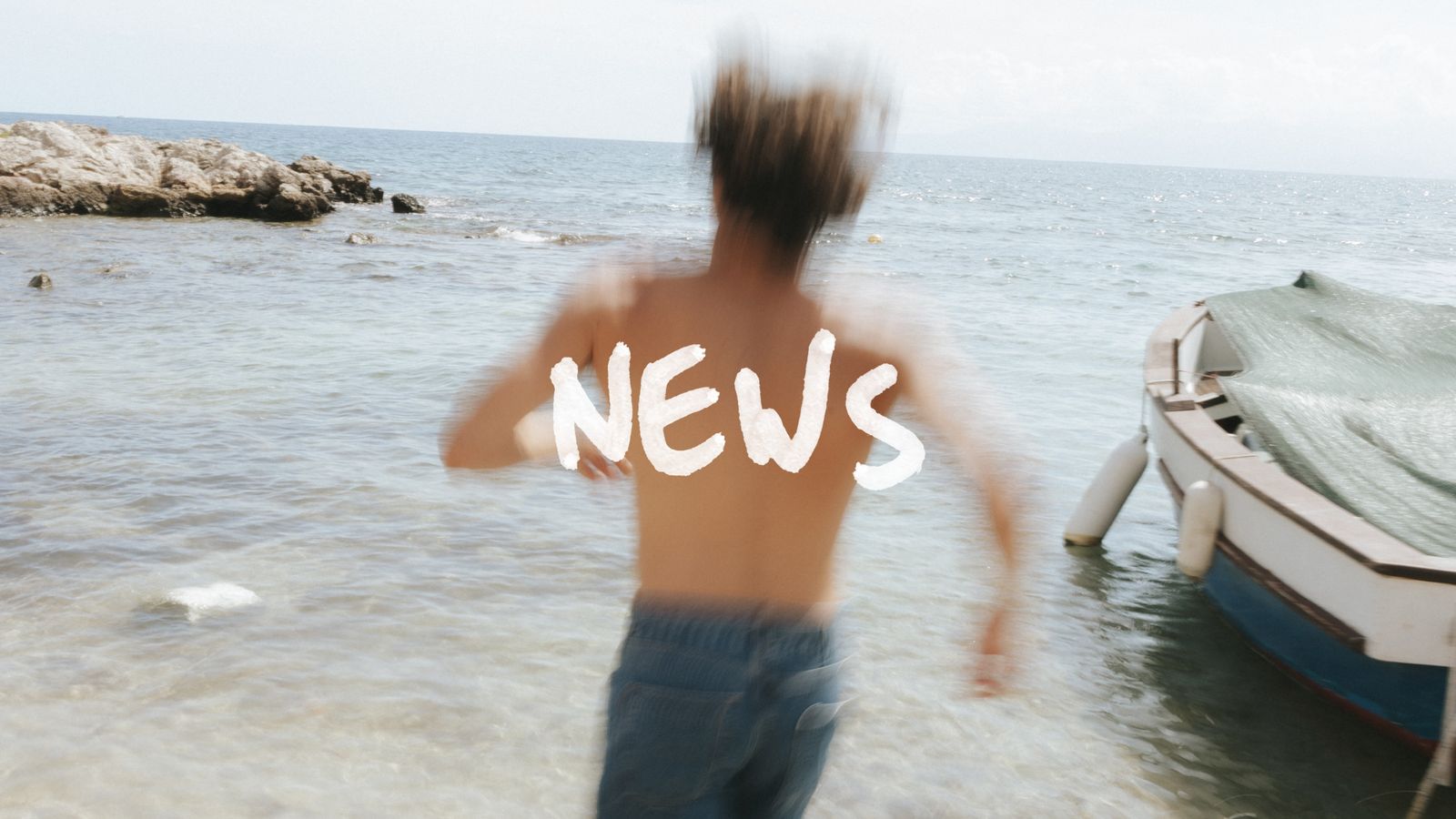 Blurred person running into the sea near a boat, with the word "NEWS" overlaid on the image.