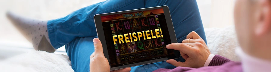 Entspannter Spieler liegt auf dem Sofa und sieht auf dem Tablet einen Slot mit großem Schriftzug „FREISPIELE!“ – Promotion für Gratis-Drehungen.