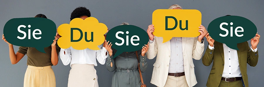 Symbolfoto: Fünf Erwachsene halten abwechselnd grüne und gelbe Sprechblasen mit den Worten „Sie“ und „Du“ vor ihre Gesichter – Illustration der Wahl zwischen formeller und informeller Kundenansprache.