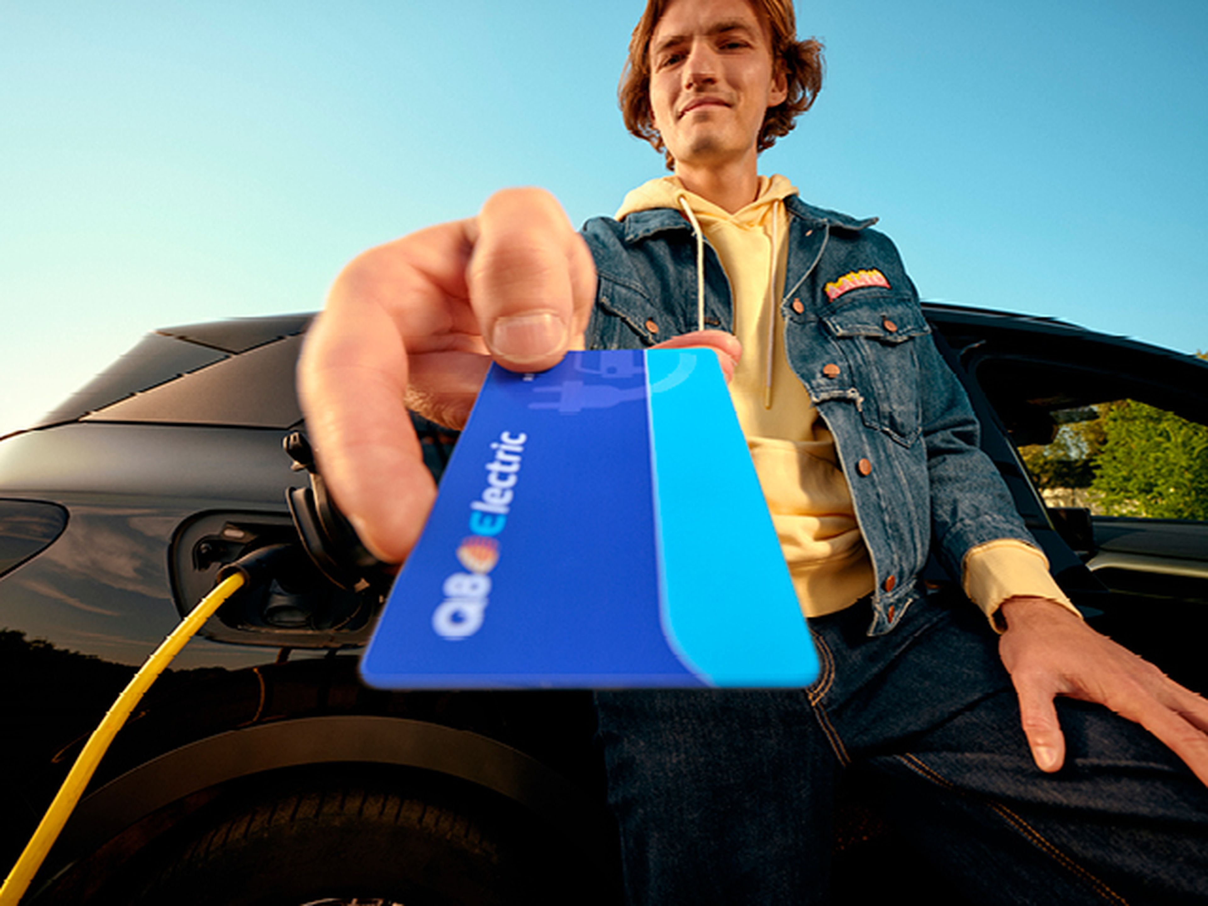 Man toont een Q8 electric laadpas bij zijn elektrische auto bij Q8.