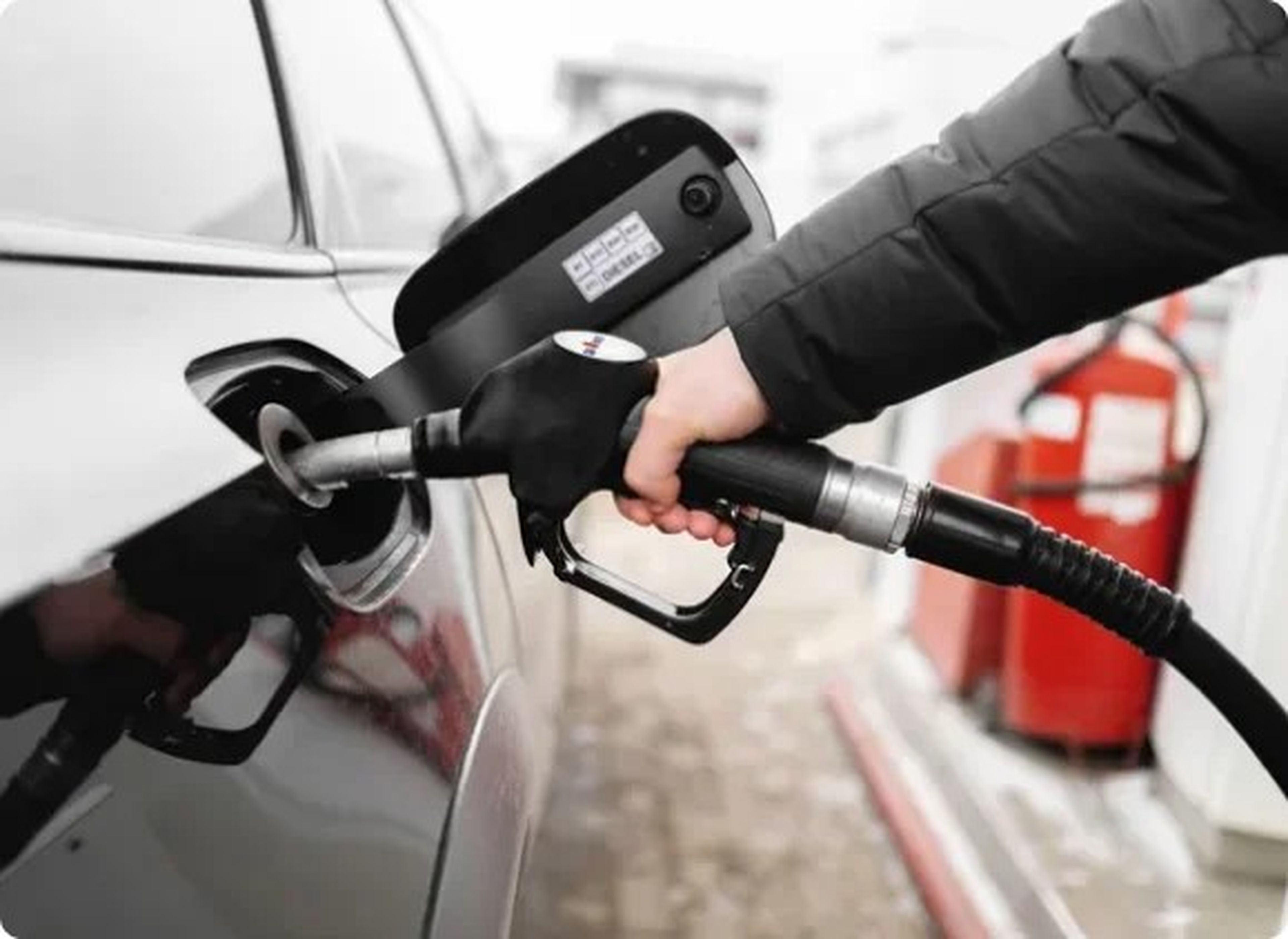 Personne en veste noire fait le plein de HVO100 dans sa voiture particulière.