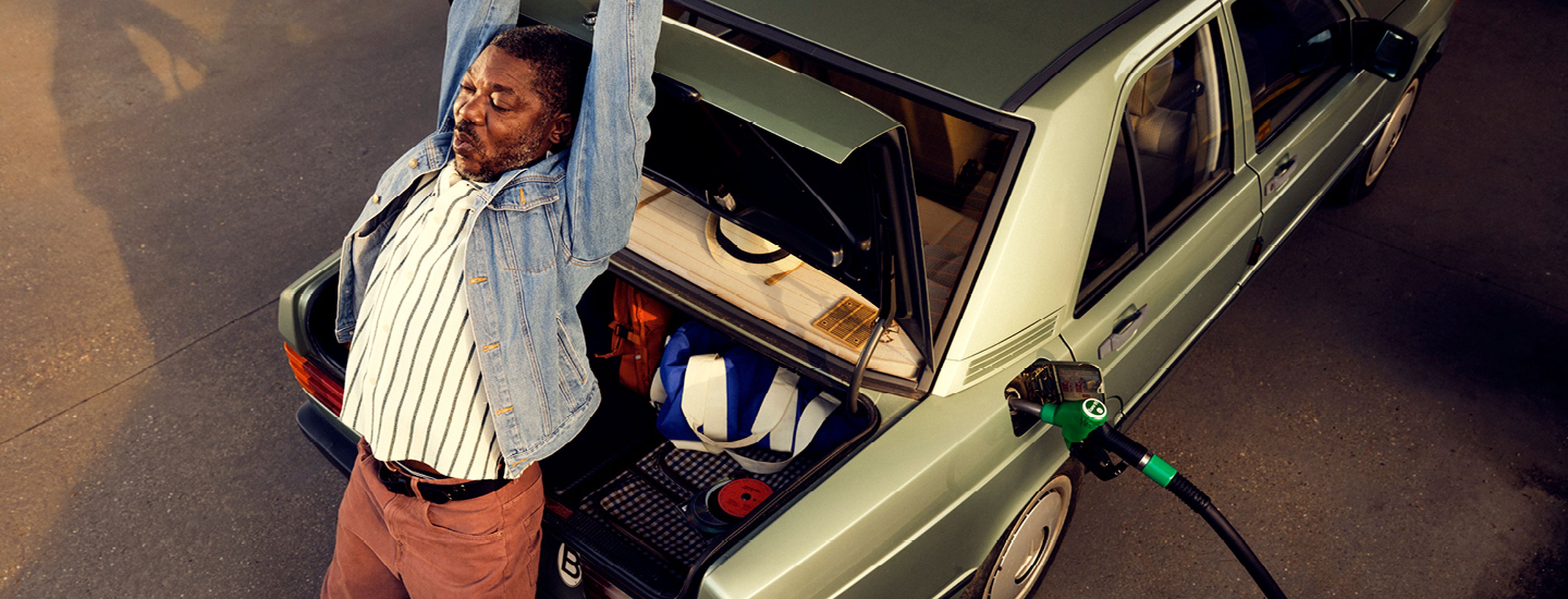 Man stretching while refueling his car at Q8.