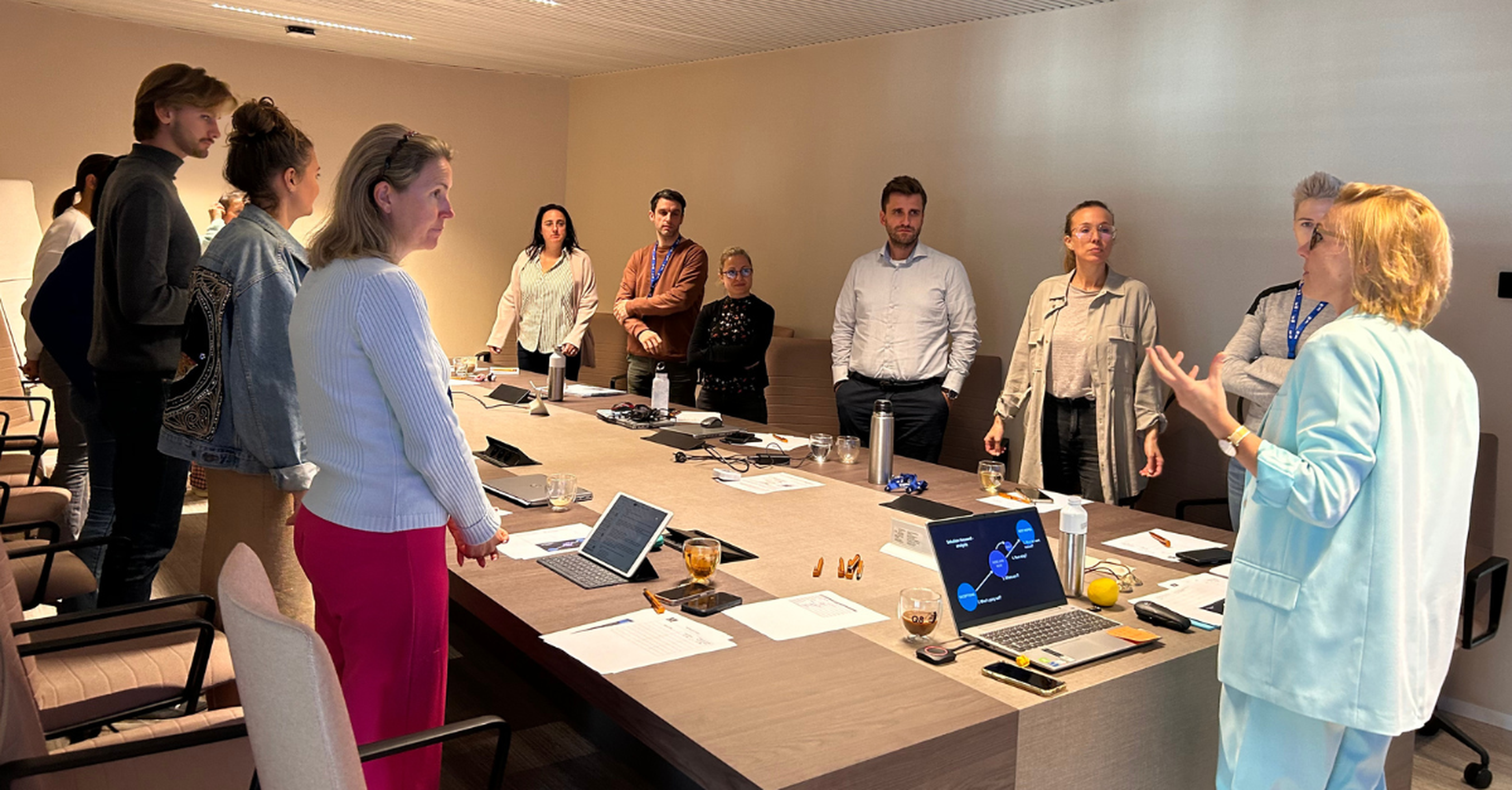 A large group of colleagues is attending a workshop at the office.