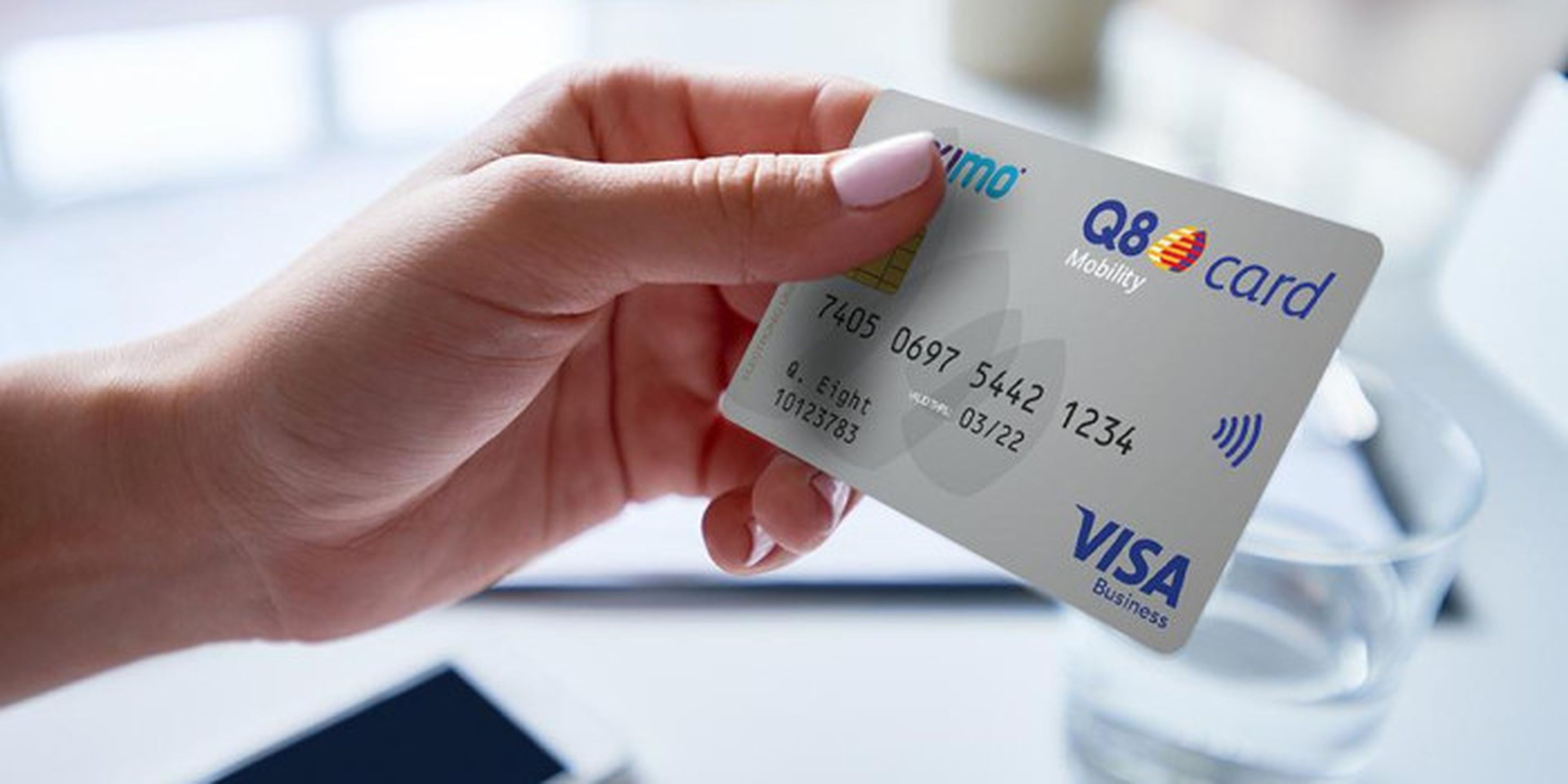 Een hand houdt een Q8 mobility card vast, een grijze zakelijke betaalkaart.