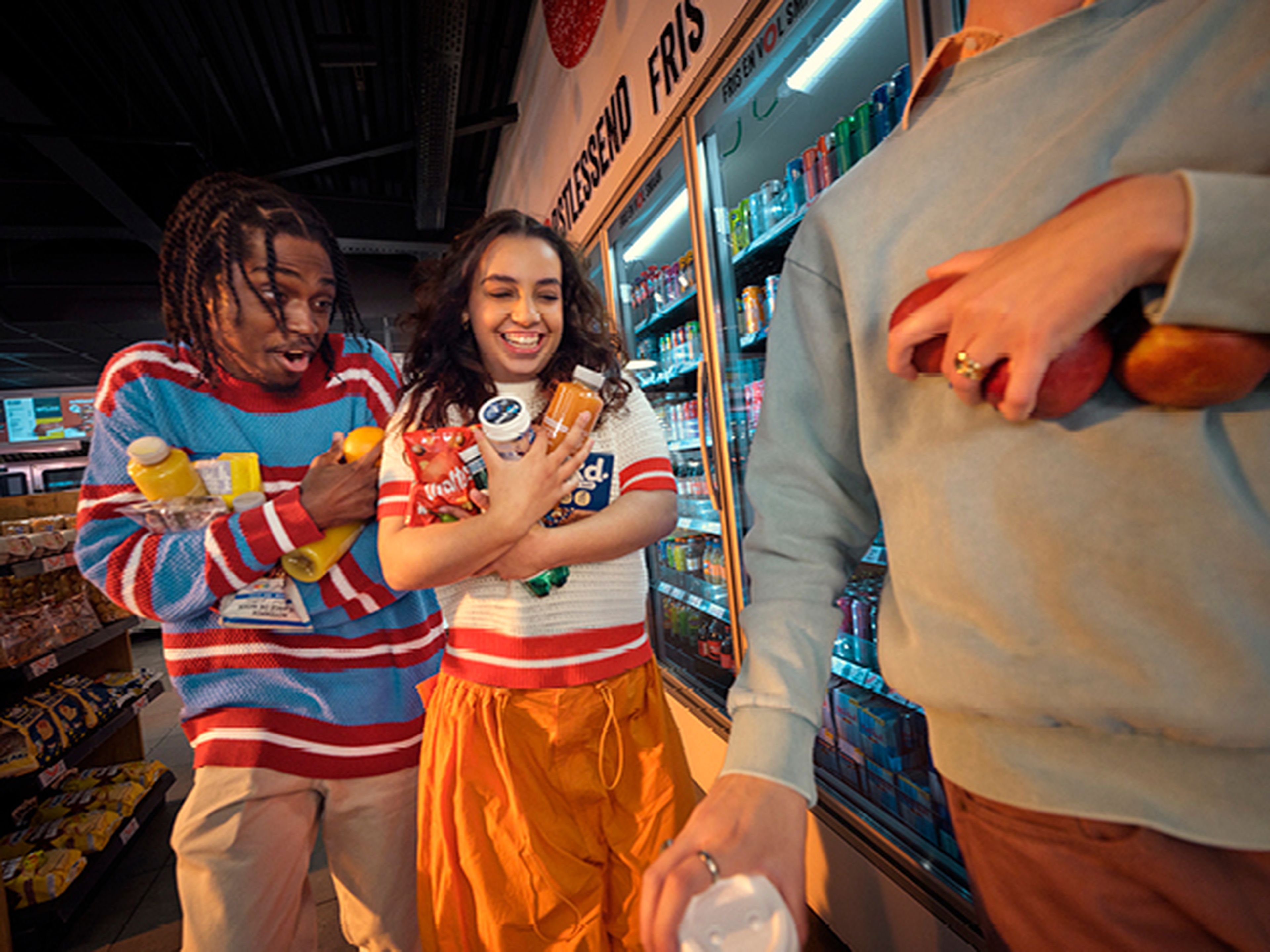 Jeunes avec des courses près des réfrigérateurs dans le Q8 Shop n Go.