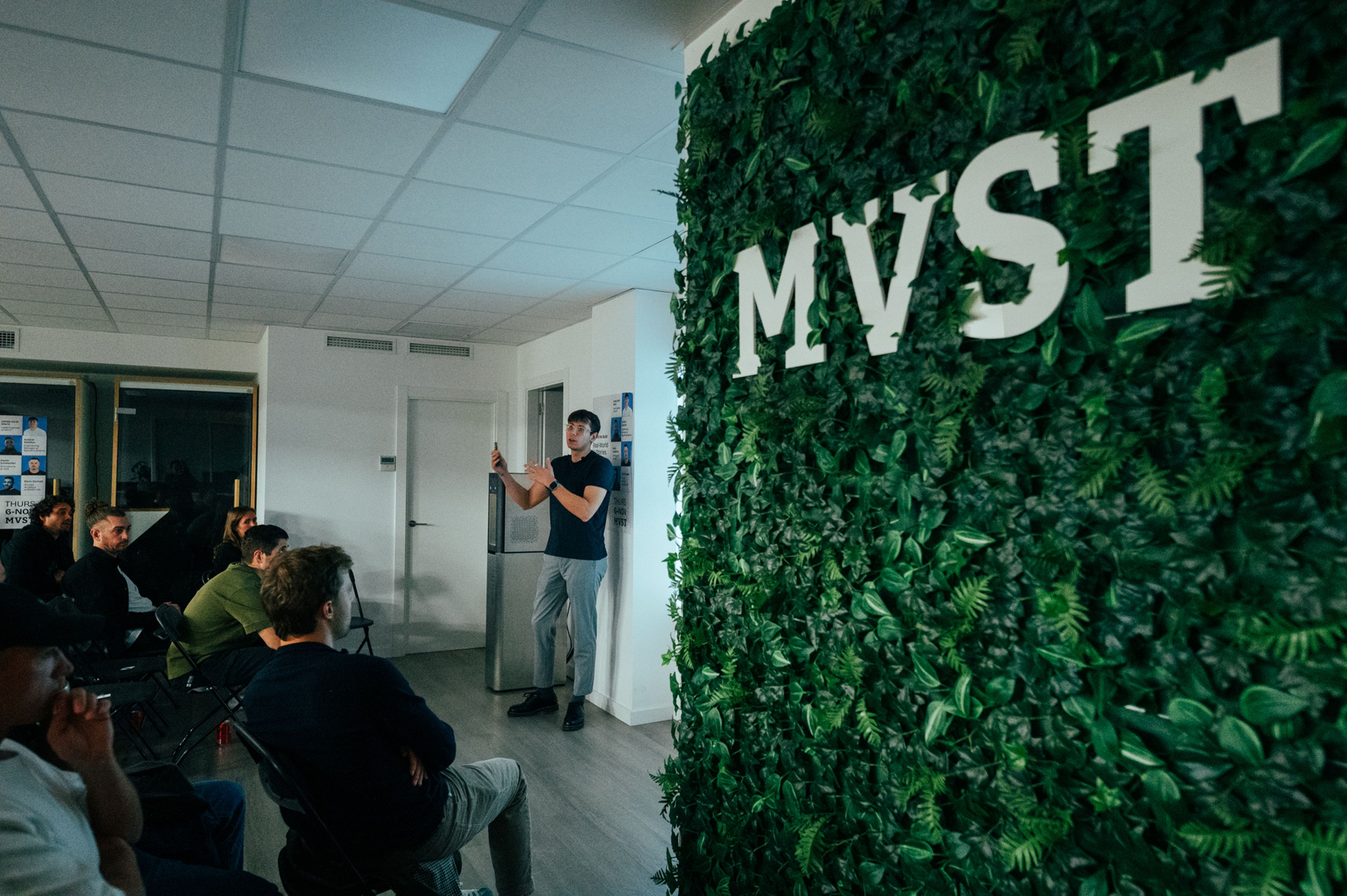 Man presenting and people sitting and watching