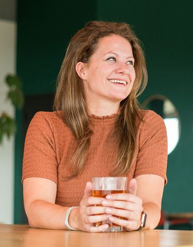 Sanne, lachend met een kop thee