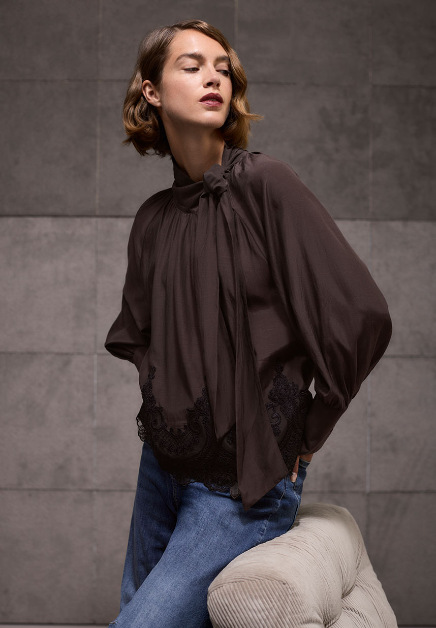 Frau in brauner Spitzenbluse