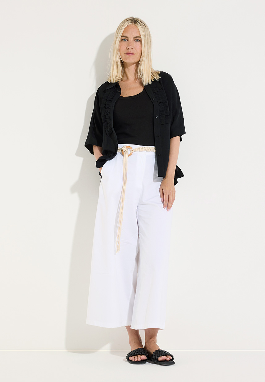 Model mit schwarzen Hemd und weißer Hose