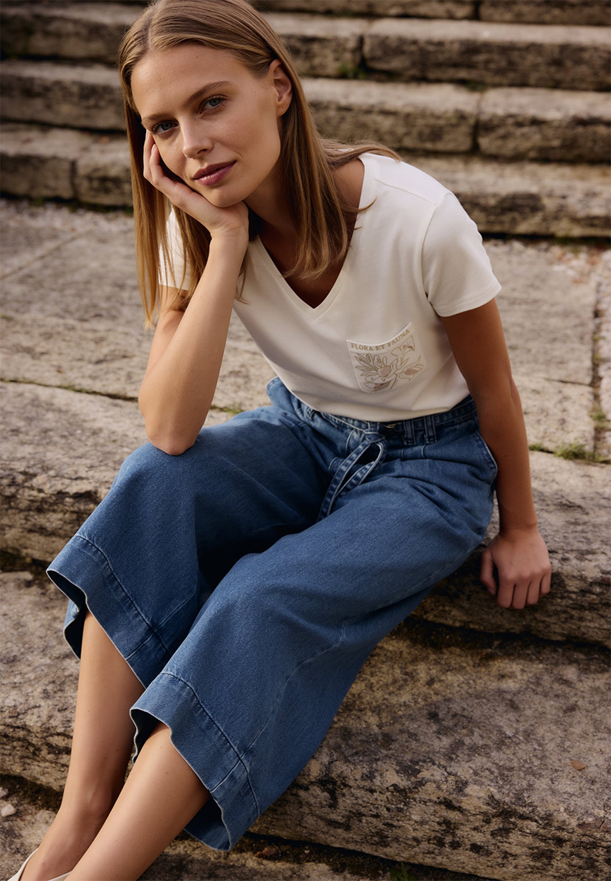 Frau mit Shirt in weiß und Denimhose