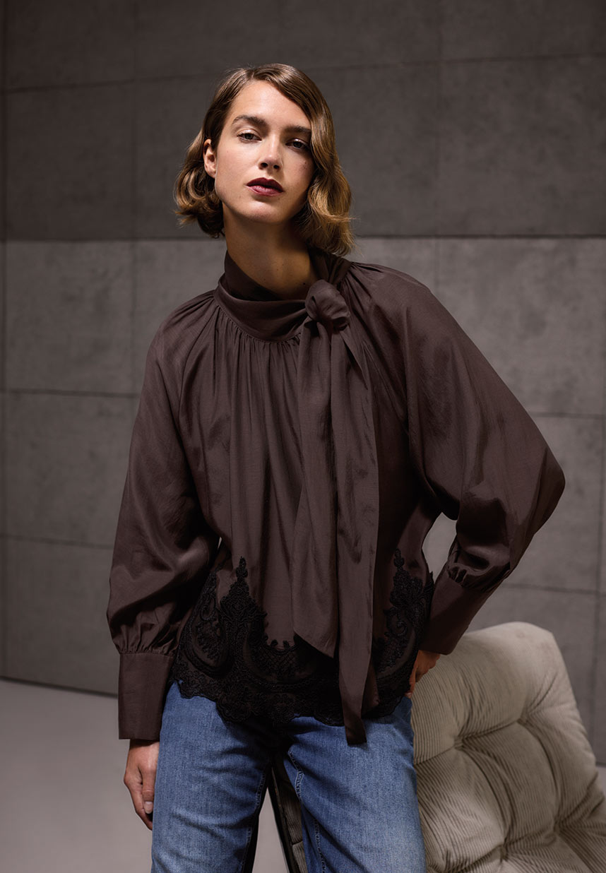 Frau in brauner Spitzenbluse