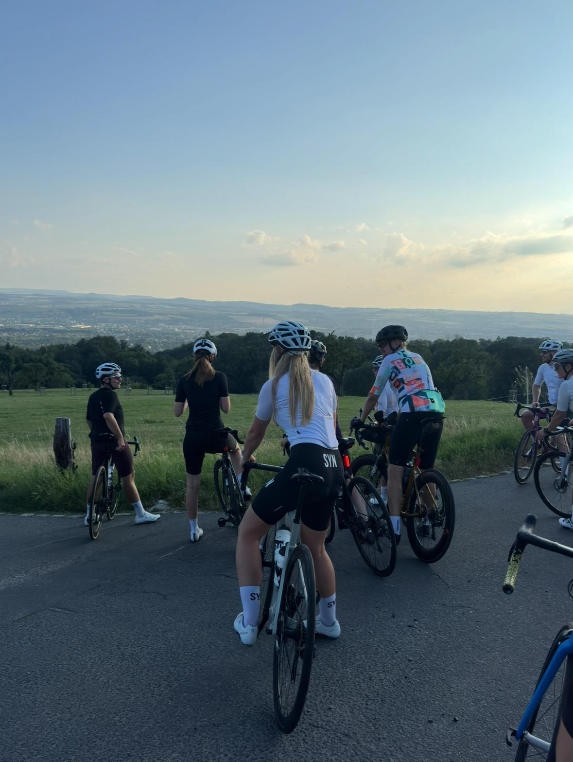 Gruppe von Radfahrern bei einem Event auf einer Landstraße bei Sonnenuntergang
