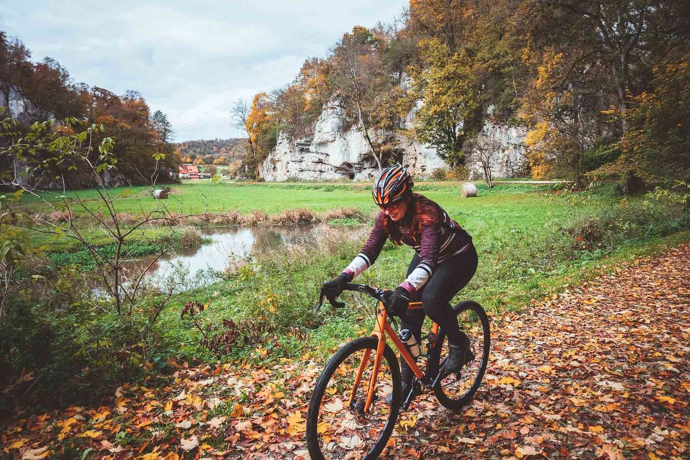 Radfahrerin mit dem Gravelbike in der Herbstlandschaft.