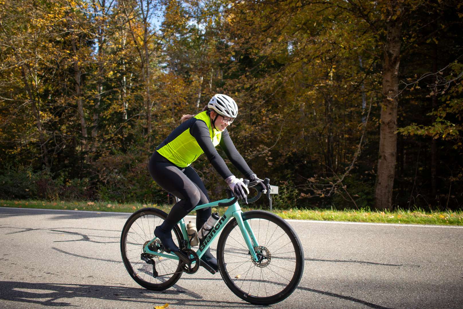 Radfahrerin auf dem Rennrad mit einer Warnweste im Herbst