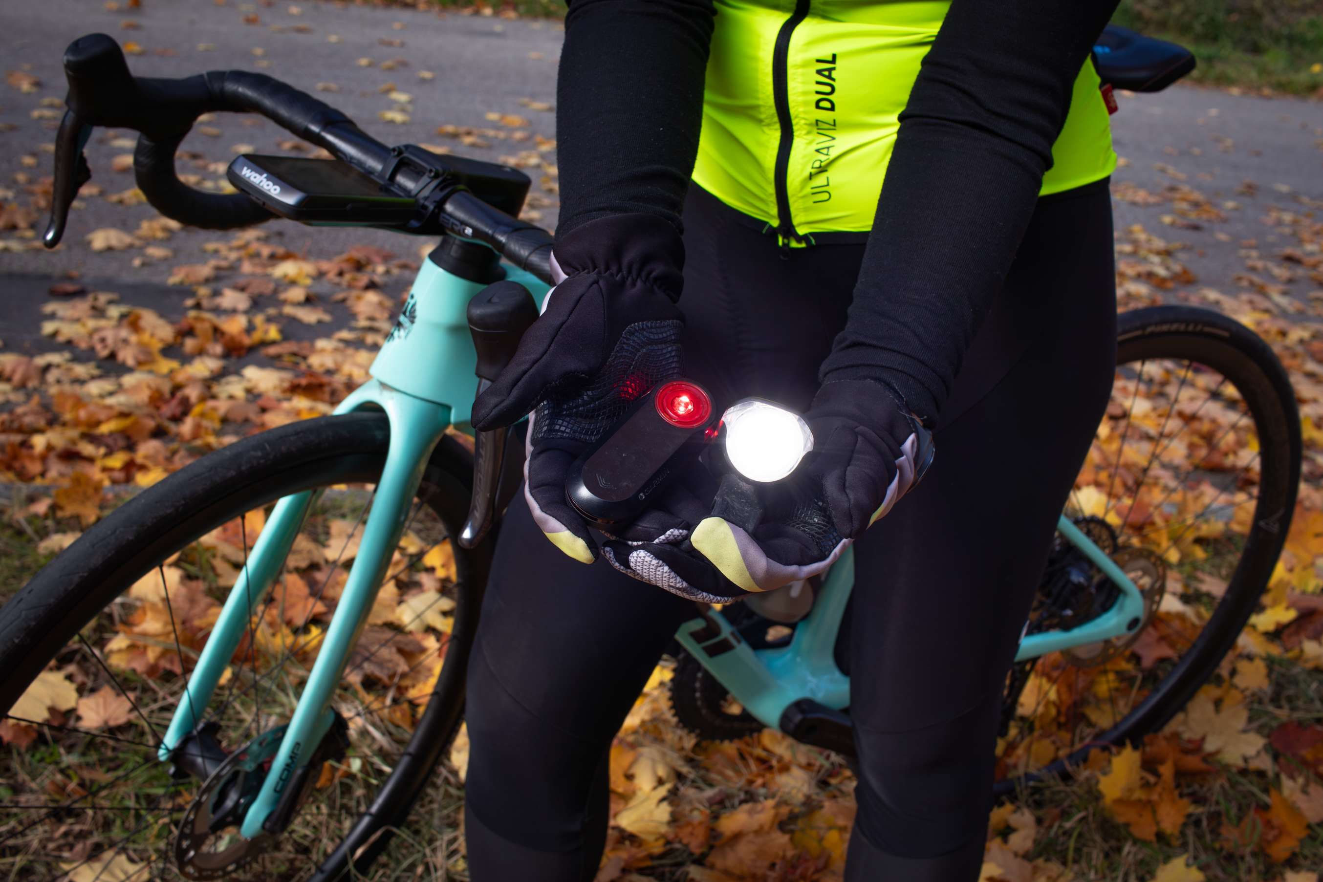 Radfahrerin hält Fahrradlichter in der Hand.