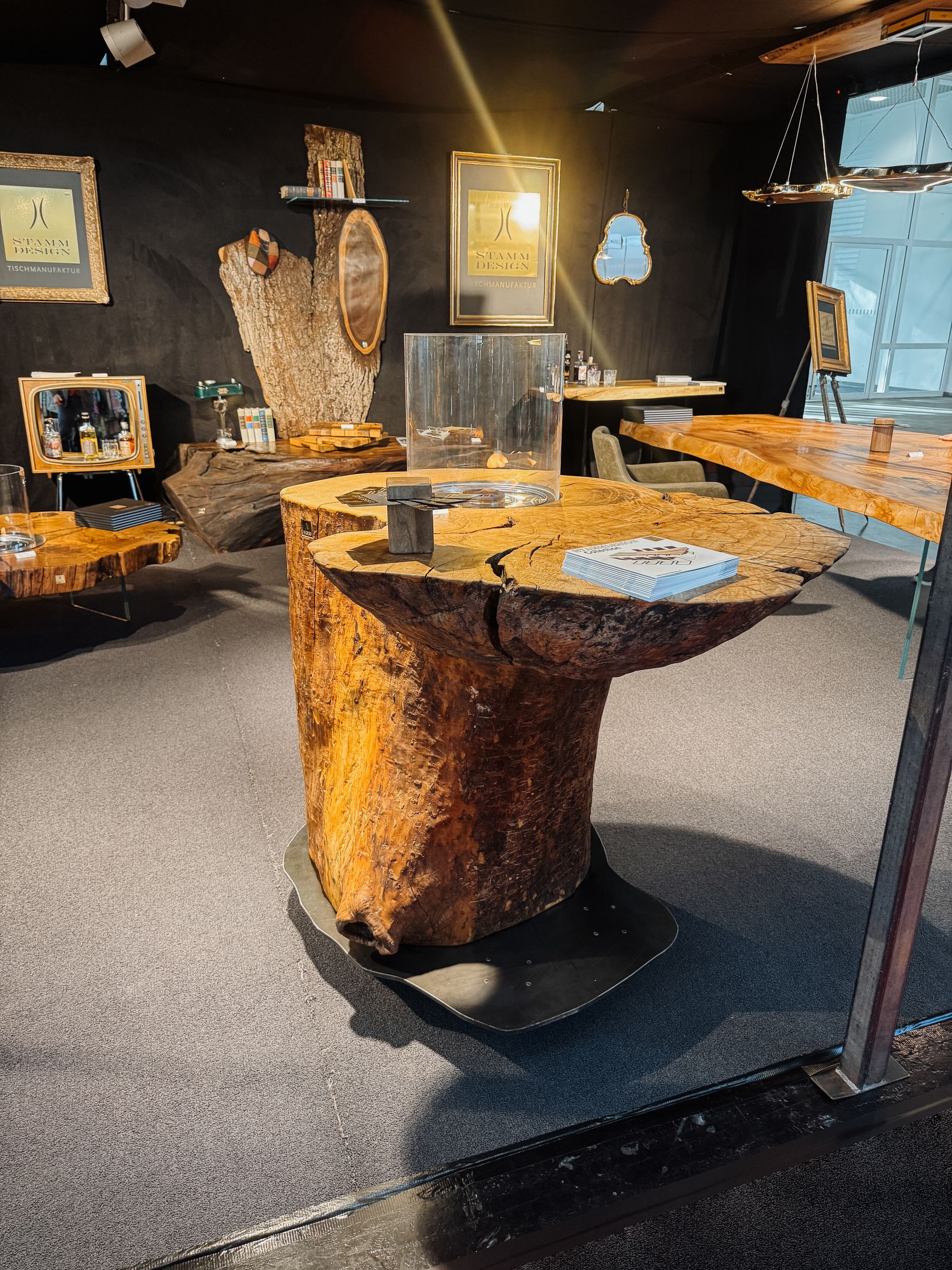 Standing table made from a whole ash trunk with natural live edge and integrated fire section