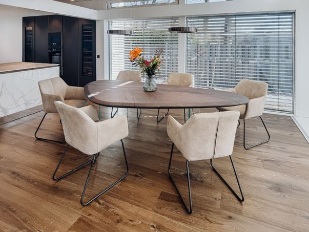 Tavolo naturale moderno in rovere con bordo dritto e gambe in vetro robuste nella sala da pranzo