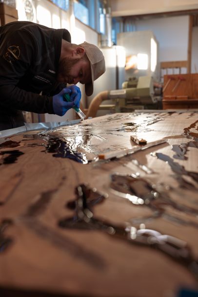 Bearbeitung eines Epoxidharz Baumstammtisches in der Stammdesign Manufaktur – modernes Designmöbel aus Massivholz