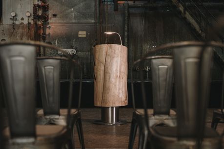 Atril de tronco macizo de Stammdesign en una antigua nave industrial