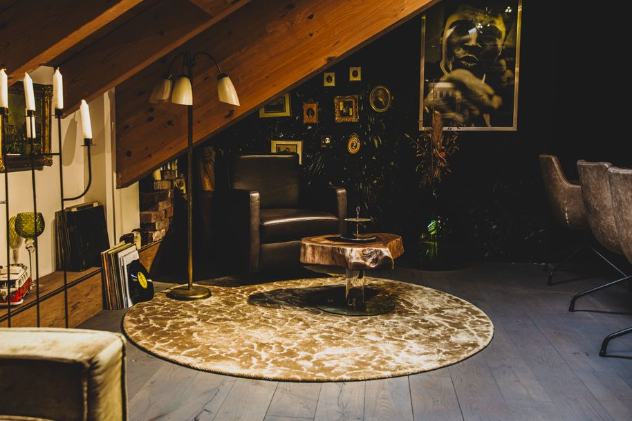 Loungebereich mit Couchtisch aus einem Baumstamm im Genussräumchen von Stammdesign