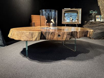 Feuer-Couchtisch aus Eiche mit charaktervoller Baumstammscheibe und Naturkante, präsentiert vor einer stilvollen Bar