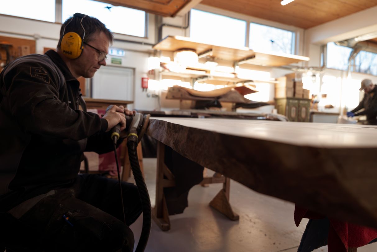 Schleifen eines Massivholz Baumstammtisches in der Manufaktur – handgefertigtes Naturmöbel aus regionalem Holz