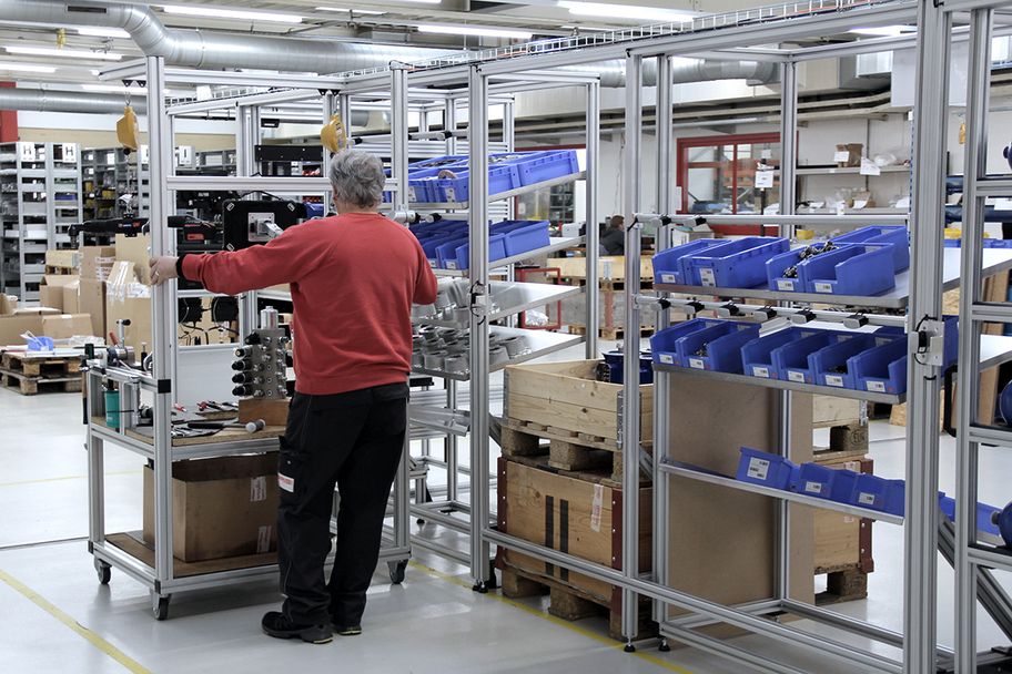 Employee assembles along a shelf on an assembly trolley