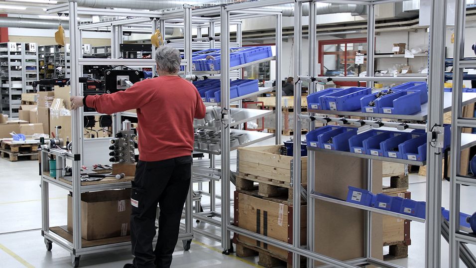 Employee assembles along a shelf on an assembly trolley