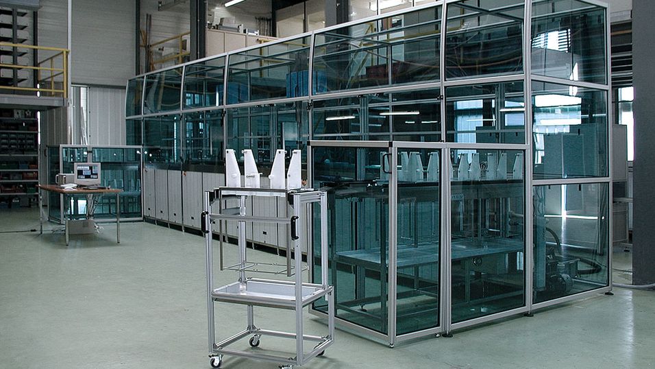 Machine enclosure with curved aluminium profiles and plexiglas panes