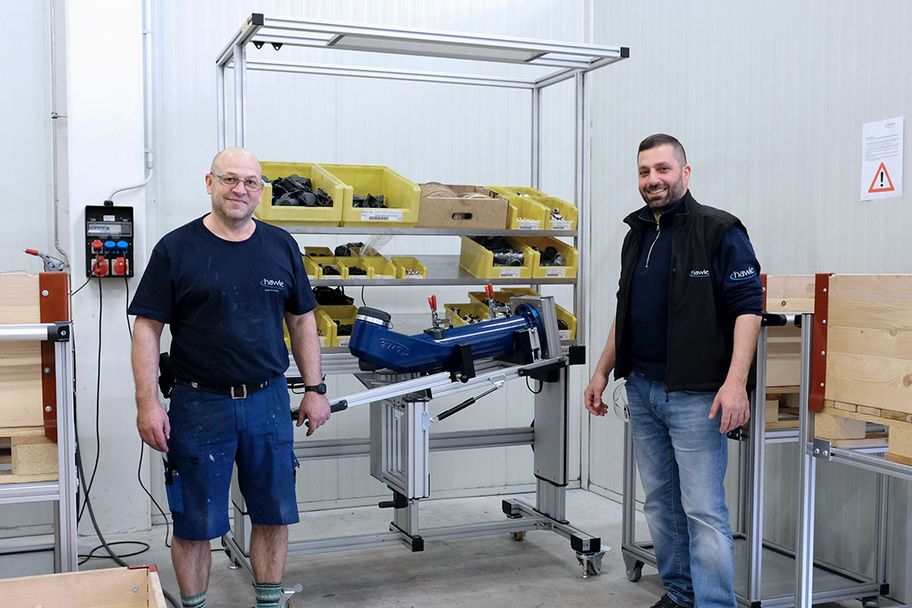 Two employees stand in front of an assembly workstation with a swivelling device