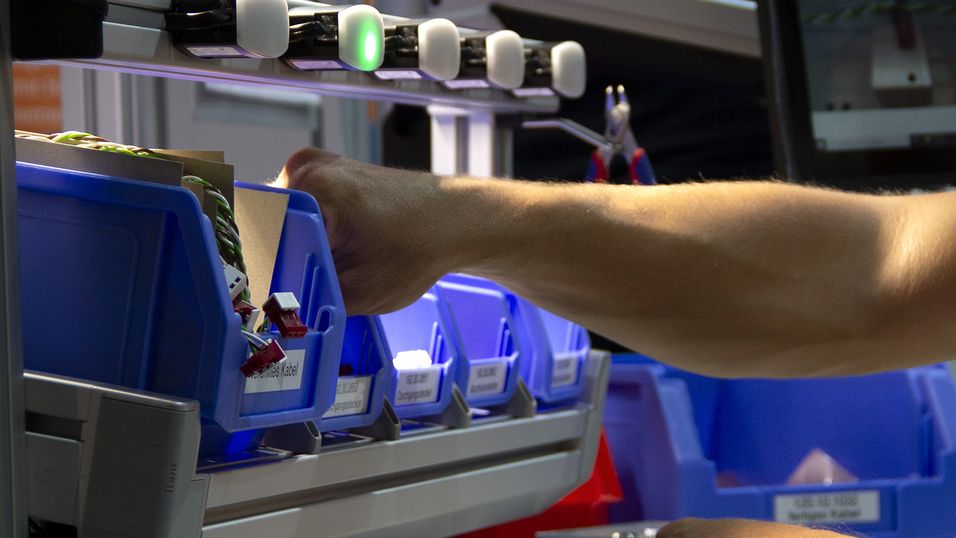 Employee grabs a component that the sensor indicates to him