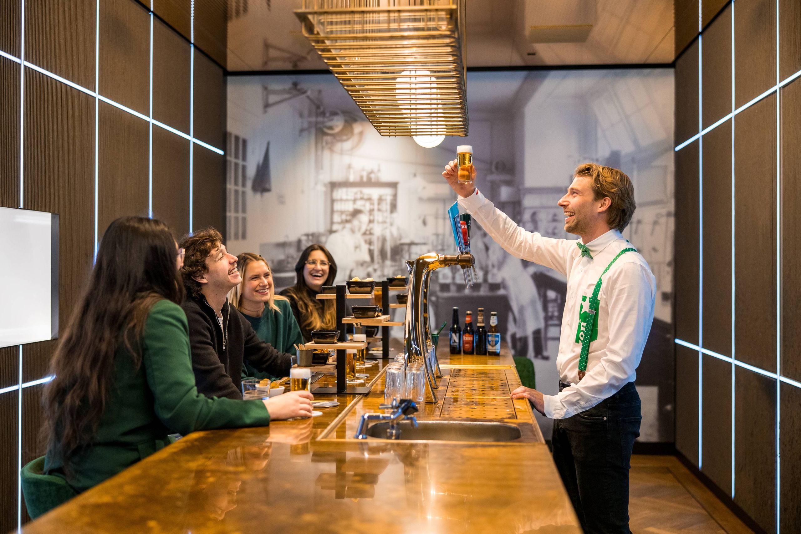 A group of people enjoying a beer tasting experience at a stylish bar.