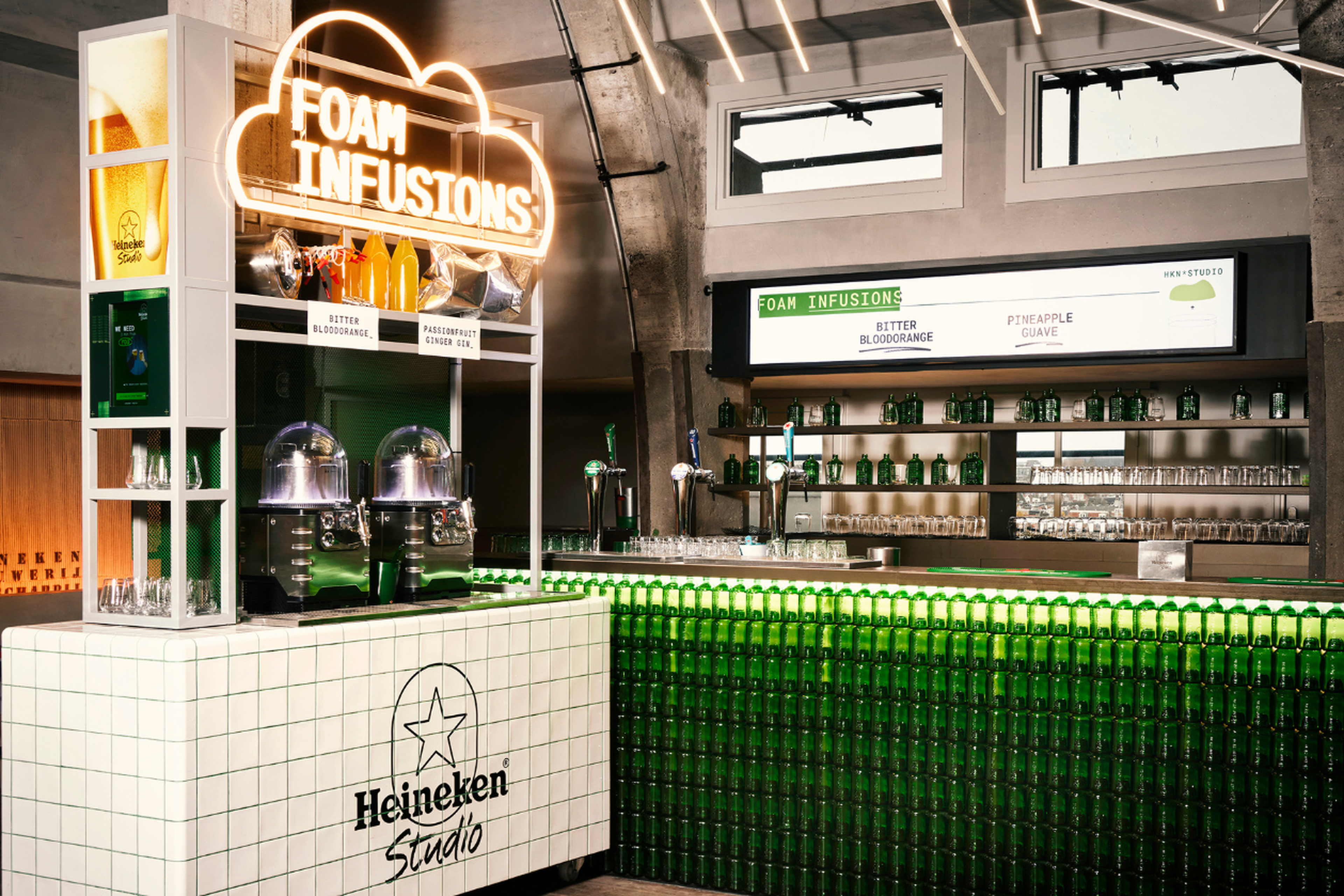 A vibrant bar area featuring the Heineken Studio with foam infusion options displayed.