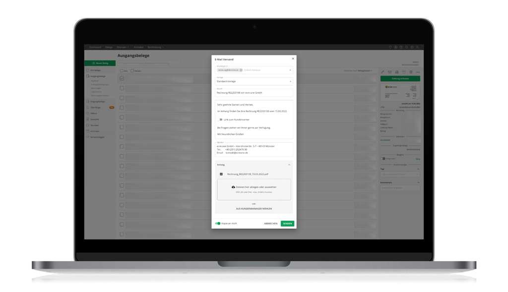 A laptop displaying an email composing window for sending an invoice, with file attachment options visible on the screen.