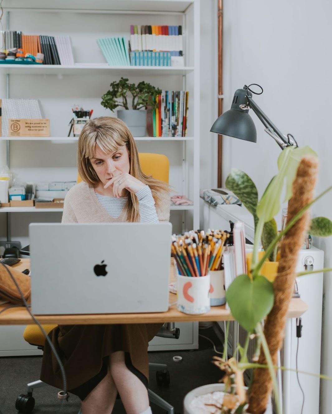 Lauren Harvey from Full Stop, working at her desk in front of her laptop.
