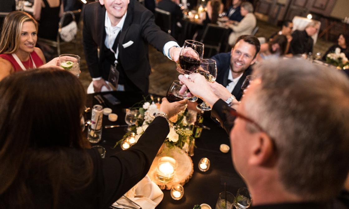 Karbon excellence awards photo. A group of Karbon X attendees toast their drinks to celebrate awards.