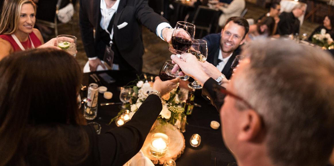 Karbon excellence awards photo. A group of Karbon X attendees toast their drinks to celebrate awards.