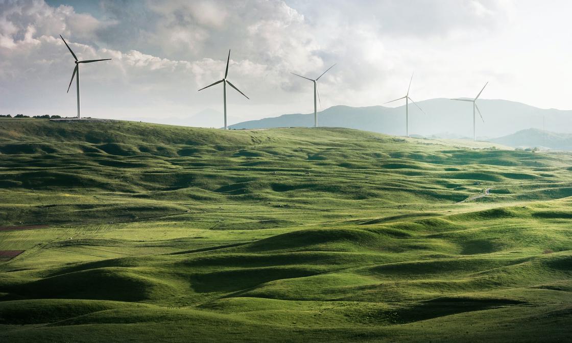 Green rolling hills with wind turbines.