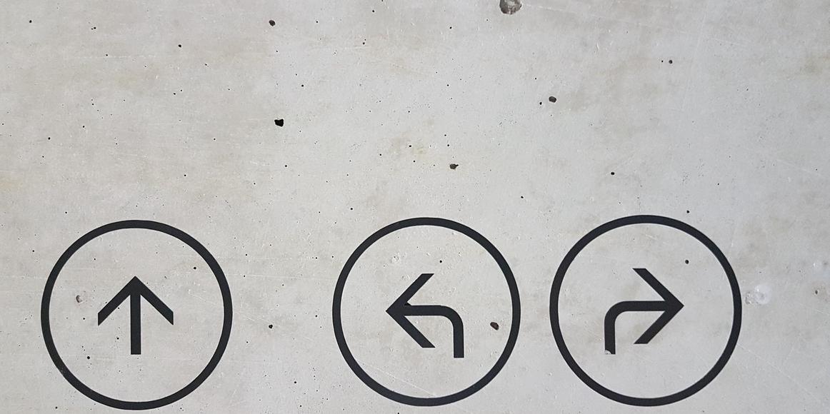 A gray concrete surface with 3 painted arrows, pointing up, left and right.