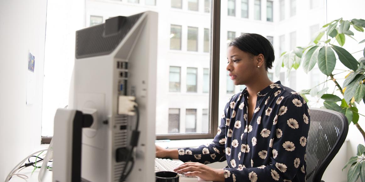 An accountant working on individual tax return forms 1040/1041 using a tax form template, in a well-lit office space.