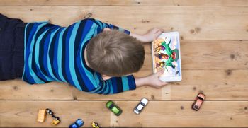 Little boy playing Brawl Stars on his tablet on the floor